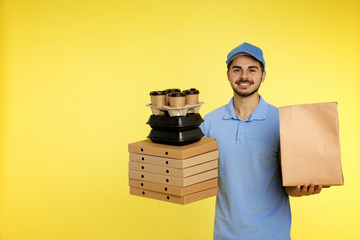 Canvas Print - Young courier with different orders on color background, space for text. Food delivery service