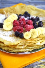 Wall Mural - Delicious hot pancakes with fresh fruit on wooden background.