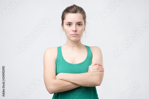Fotografering Aggravated sad woman standing crossed hands expressing her dissatisfaction and disconent