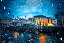 Evening View Of Dublin Ireland At The Ha'Penny Bridge Of The River Liffey With Snowflakes Falling During Winter Snow Storm