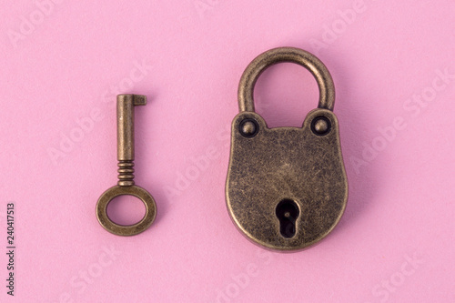 Fotomural bronze key and padlock on gently pink paper, background image