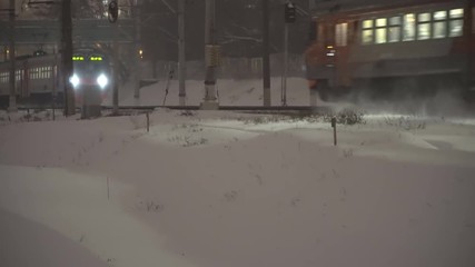 Wall Mural - Commuter train traffic at night, in the snowfall