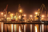 Fototapeta Londyn - Loading grain in the port. Night panoramic view of the port, cranes and other port infrastructure.