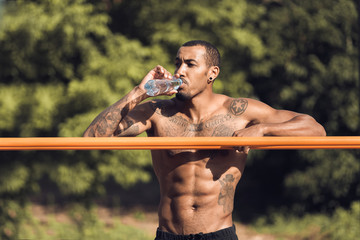 Athlete relaxing after intense workout, drinking water