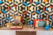 Vintage decoration with geometric wallpaper, retro tv, old portable record player, telephone and ceramic.