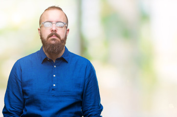 Poster - Young caucasian hipster man wearing glasses over isolated background with serious expression on face. Simple and natural looking at the camera.