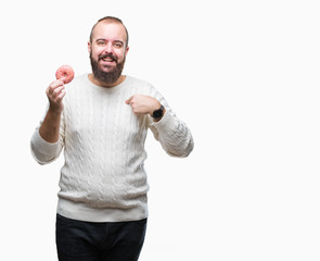 Sticker - Young caucasian hipster man eating sweet donut over isolated background with surprise face pointing finger to himself