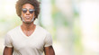 Afro american man wearing sunglasses over isolated background with serious expression on face. Simple and natural looking at the camera.