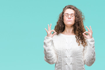 Beautiful brunette curly hair young girl wearing winter sweater over isolated background relax and smiling with eyes closed doing meditation gesture with fingers. Yoga concept.