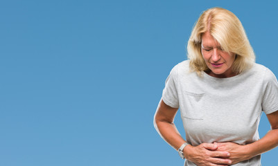 Canvas Print - Middle age blonde woman over isolated background with hand on stomach because nausea, painful disease feeling unwell. Ache concept.