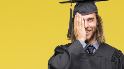 Sticker - Young handsome graduated man with long hair over isolated background covering one eye with hand with confident smile on face and surprise emotion.