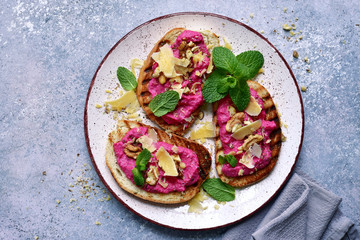 Toasts with beetroot paste, parmesan cheese, walnut and mint.Top view with copy space.