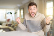 © Krakenimages.com - Young handsome man at home celebrating surprised and amazed for success with arms raised and open eyes. Winner concept.
