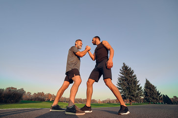 The two opponents holding hands in the park