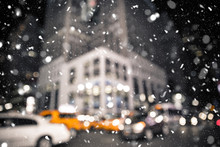 Defocused Blur New York City Midtown Manhattan Street Scene With Yellow Taxi Cab And Snowflakes Falling During Winter Snow Storm