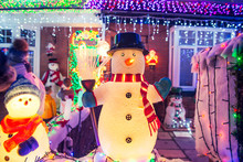 Decorative Snowmen With Lights And Shiny Outdoor Christmas Decorations At Night. Merry Xmas And New Year Outside Exterior Decor. Selective Focus, Copy Space.