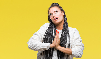 Sticker - Young braided hair african american girl wearing sweater over isolated background begging and praying with hands together with hope expression on face very emotional and worried