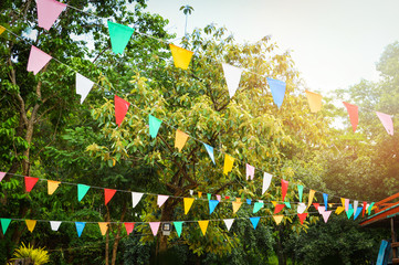 Wall Mural - Colorful party flags made of paper / Triangle paper flag hang in the garden decorate in event