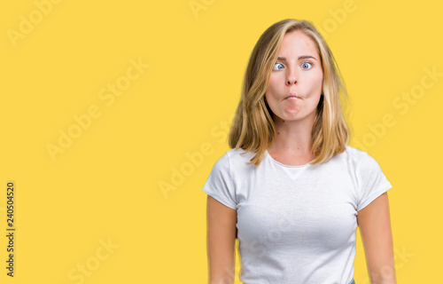 Fotomural Beautiful young woman wearing casual white t-shirt over isolated background making fish face with lips, crazy and comical gesture