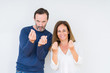 © Krakenimages.com - Beautiful middle age couple in love over isolated background Doing money gesture with hand, asking for salary payment, millionaire business
