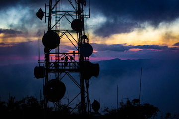 Telecommunication transmitting tower at dawn on top