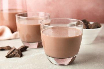 Glasses with tasty chocolate milk on table. Dairy drink