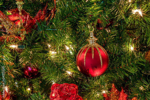 Red And Green Ornaments On A Christmas Tree With White Lights