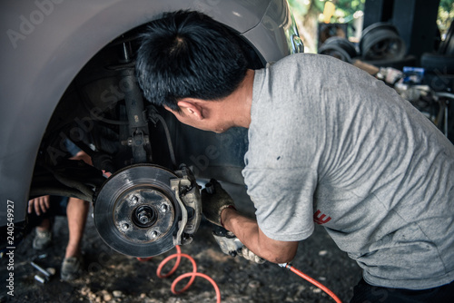 Car Mechanics Are Changing Brake Pads In The Garage Buy This
