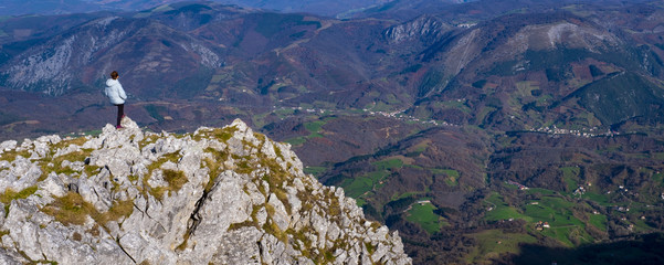 Girl on the top of the mountain, Senderista admiring the landscape from the top of Mount Irumugarrieta in the Sierra de Aralar.