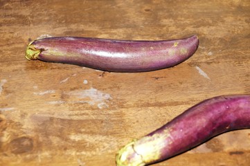 Fresh eggplants on dark wooden background. Vegetarian food, health or cooking concept. Selected focus. Close up.