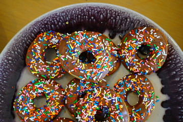 Wall Mural - Fresh donuts with chocolate icing and colorful sprinkles