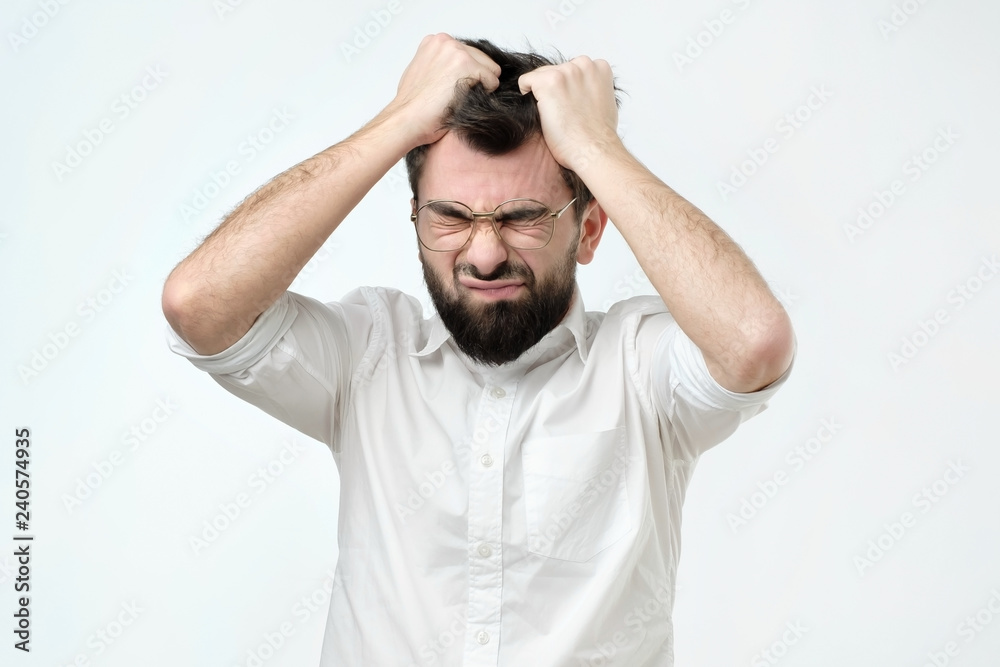 Enraged young businessman pulling his hair out for exasperation, having a burnout at work, screaming for frustration and stress - obrazy, fototapety, plakaty 