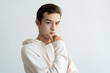 © Mangostar - Thoughtful teen boy touching chin and looking at camera. Handsome young guy thinking. Contemplation concept. Isolated view on white background.