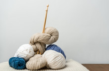 Close Up View Of Knitting Clews With Knitting Needles On Grey Backdrop