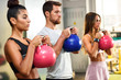 © Westend61 - Young people doing kettle ball workout in a gym