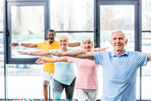 Multicultural Senior Athletes Synchronous Doing Exercise At Gym