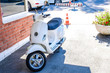White scooter in the summer Parking lot outside the building