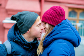 young male and female couple kissing outdoor in the street on the winter day f