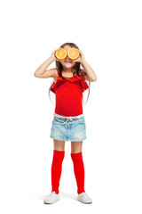 Wall Mural - Full length portrait of cute little kid girl in stylish jeans clothes with orange standing against white studio wall. Kids fashion concept