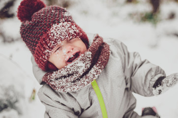 Wall Mural - Happy girl child with snow on face at winter landscape, outdoors