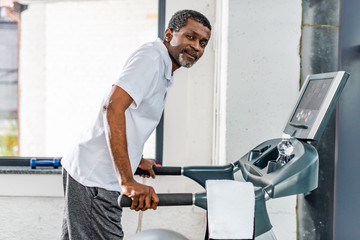 Wall Mural - middle aged african american man on treadmill at gym