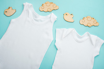 layout flat. put on a two white children's body shirt, with wooden toys on a blue background. layout