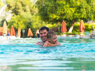 Father and child swimming in the pool