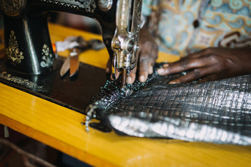 woman using an old sewing machine in Uganda, Africa