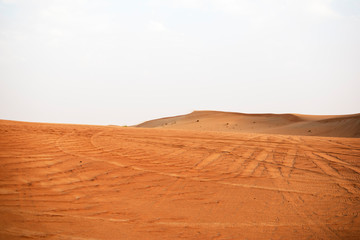  Detail of tyre tracks in sand desert with sky background