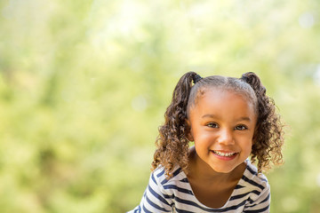 cute mixed race little girl laughing and smiling.