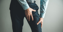 Man Thigh Pain From Cramp On Gray Background