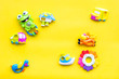 © 9dreamstudio - Handmade toys for newborn baby. Rattle. Yellow background top view mockup