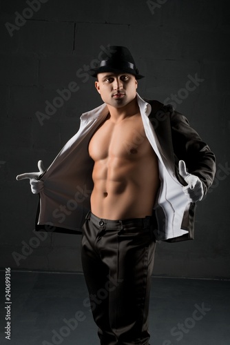 Fotografie, Obraz Young muscular man in a hat and unbuttoned shirt