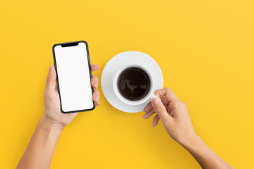 Woman holding mobile phone and coffee cup